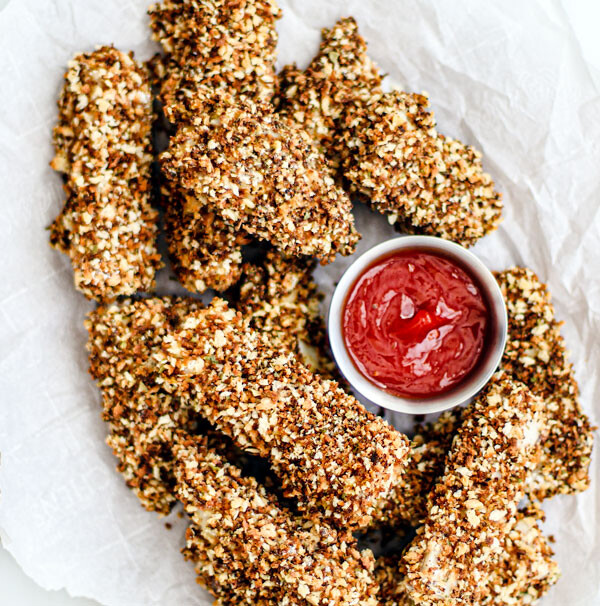 Platter of crispy homemade fish sticks with dipping saucer of ketchup.