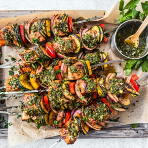 Salmon kebabs slathered in chimichurri on a serving platter.