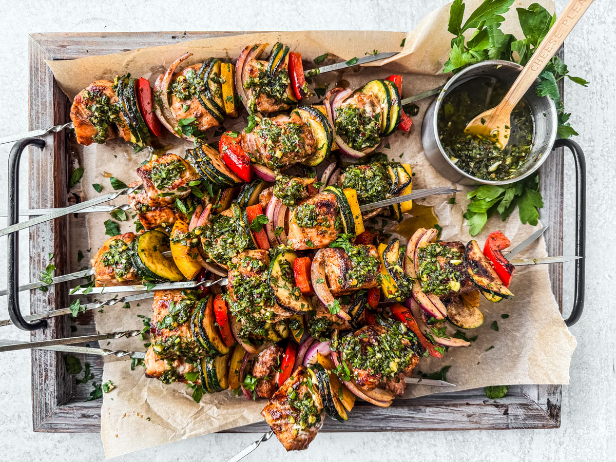 Salmon kebabs slathered in chimichurri on a serving platter.