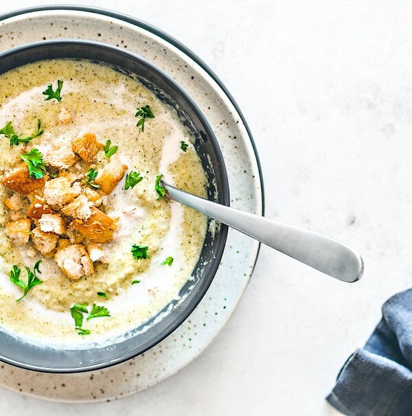 Bowl of cream of broccoli soup garnished with croutons.