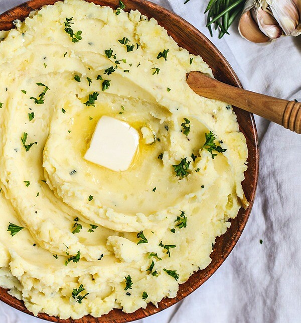 Big buttery bowl of mashed potatoes with roasted garlic and rosemary.