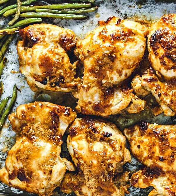 Chicken Thighs slathered in peanut sauce on a sheet pan with green beans.