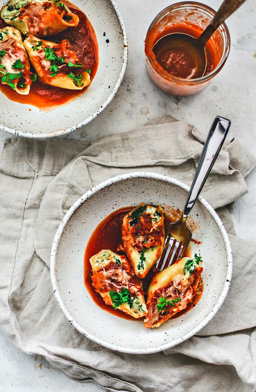 Stuffed pasta shells served in bowls with sauce.