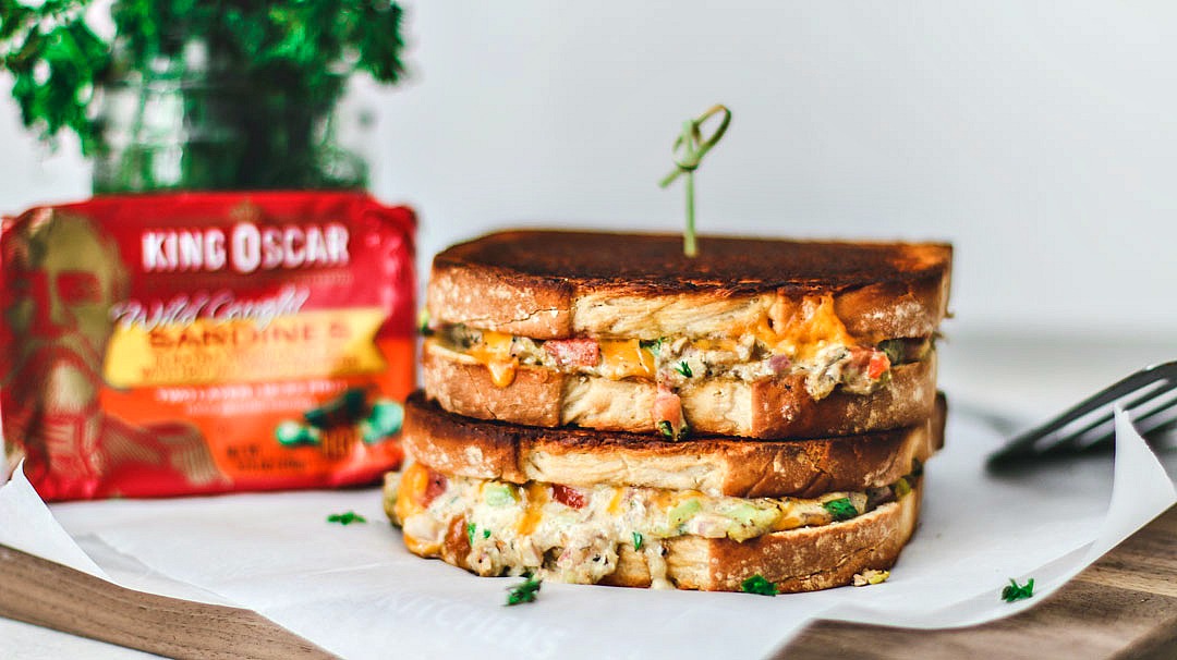 Cheddar Jalapeño Gourmet Grilled Cheese sandwiches stacked on top of one another in a melted mess.