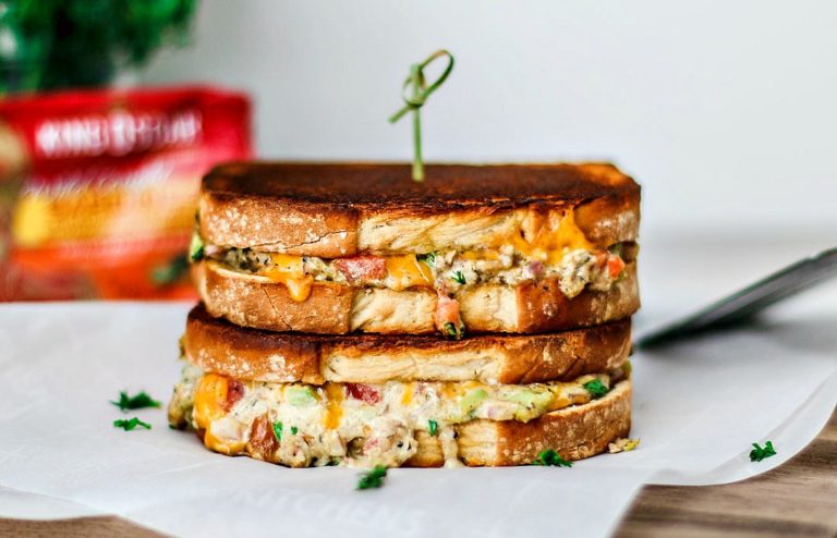 Cheddar Jalapeño Gourmet Grilled Cheese sandwiches stacked on top of one another in a melted mess.