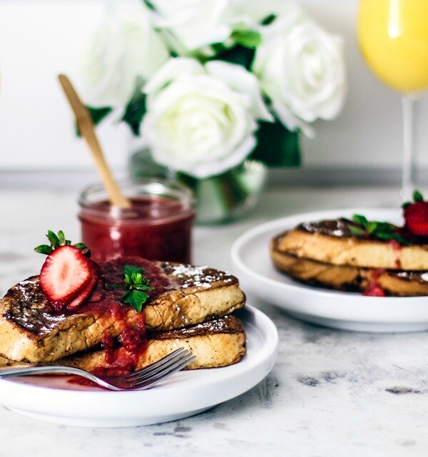 Pretty springtime table setting with stacks of french toast and mimosas.