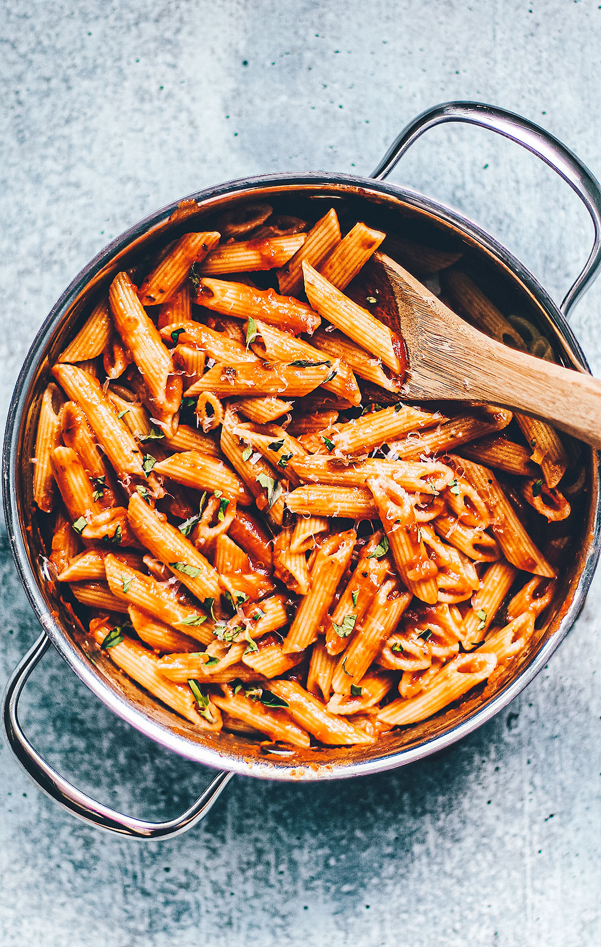 Penne pasta tossed in marinara sauce in a serving pan.