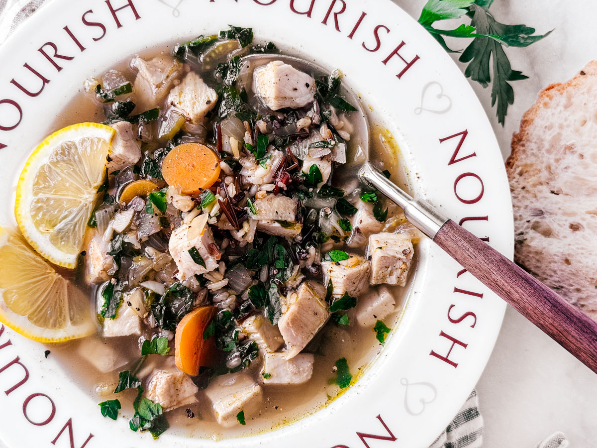 Turkey and wild rice soup in a bowl with a spoon.