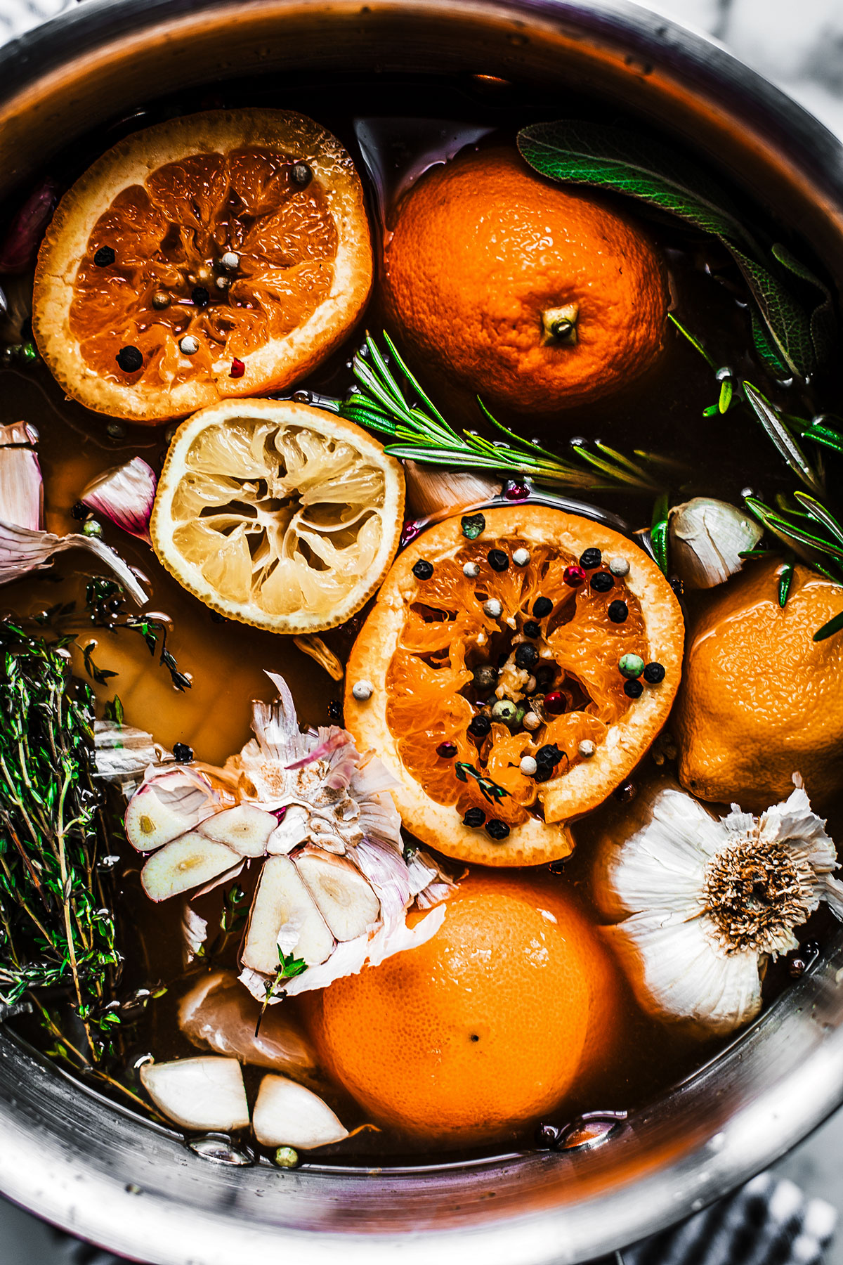 Stock pot full of apple cider, citrus fruit, garlic, herbs, etc.