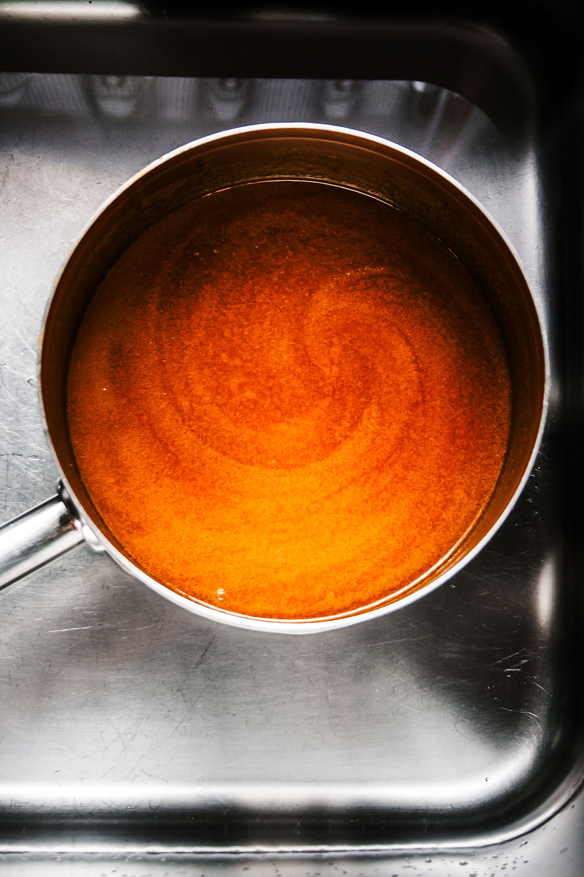 Saucepan of brined with melted sugar and salt.