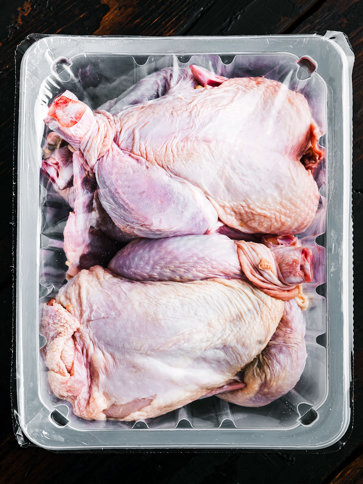 Uncooked turkey in a plastic-lined bin.