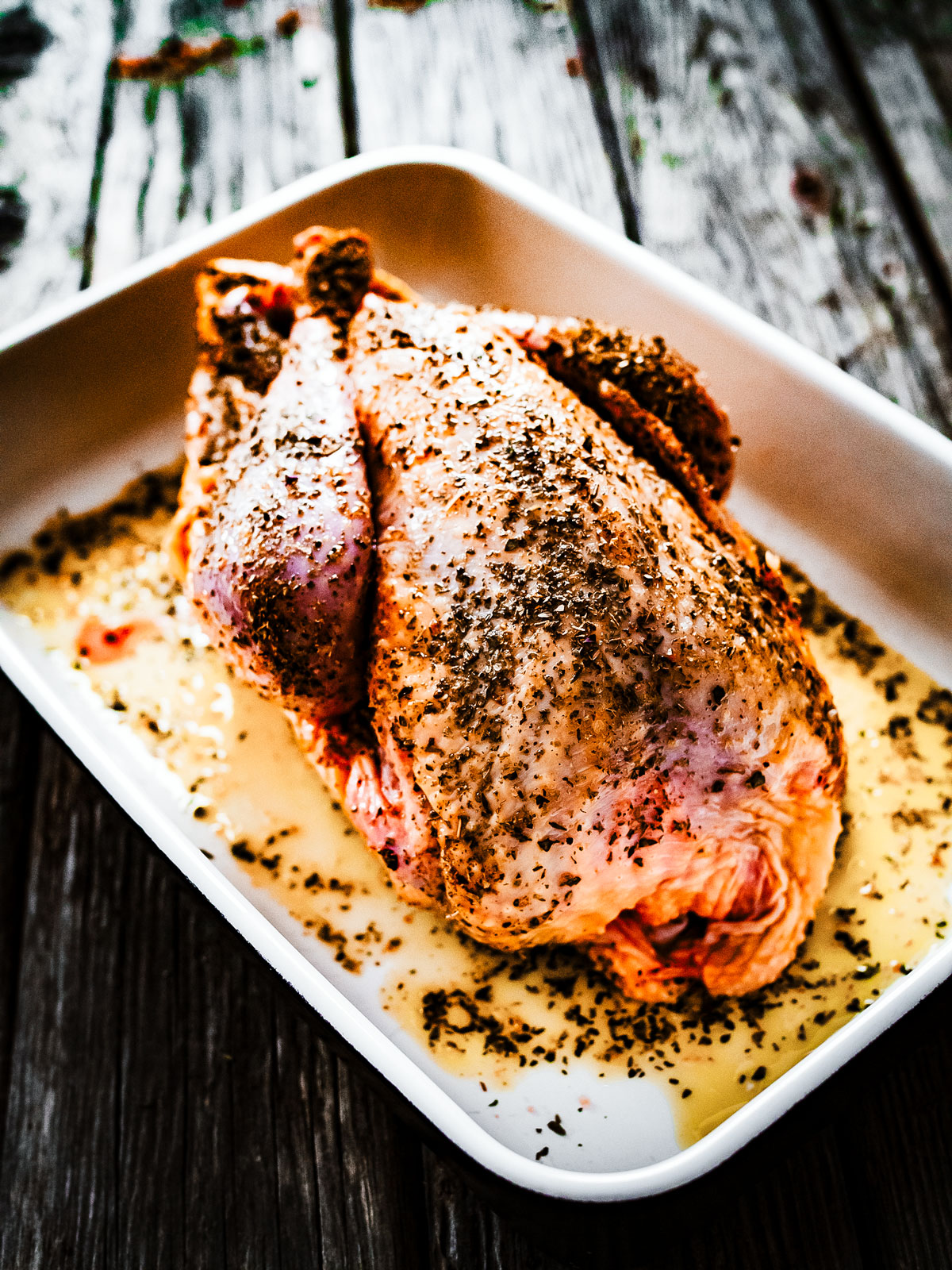 Uncooked turkey seasoned in a baking dish.