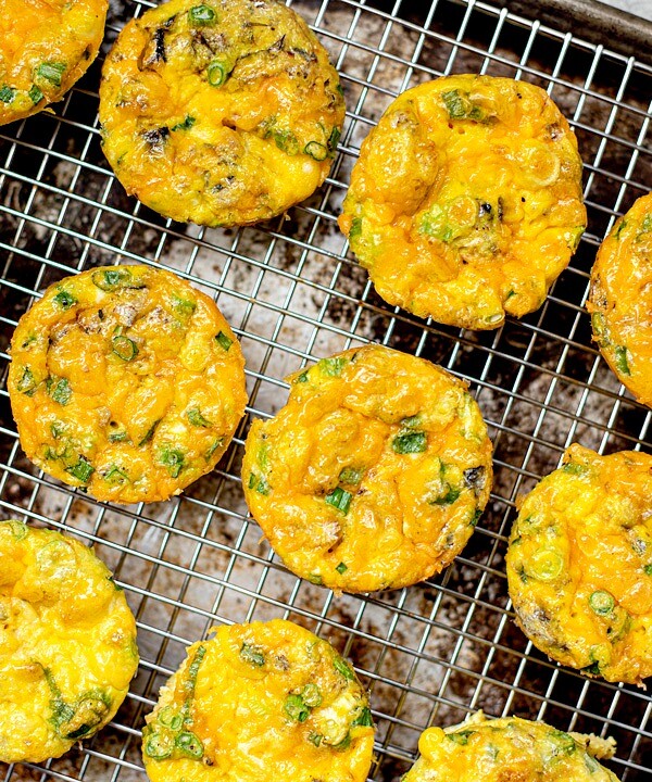 Cheesy egg muffins on a cooling rack.