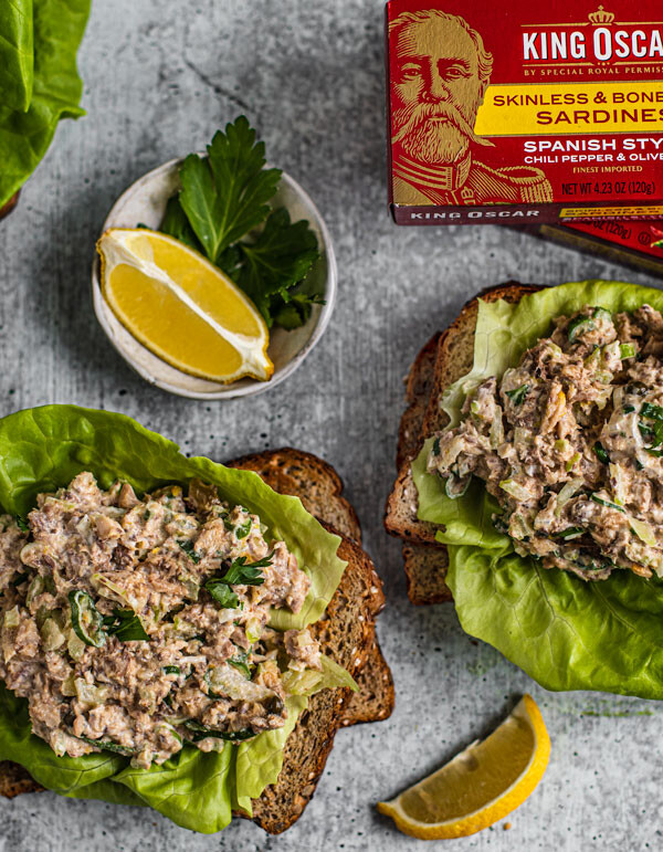 Slices of toasted bread topped with bibb lettuce and sardine salad.