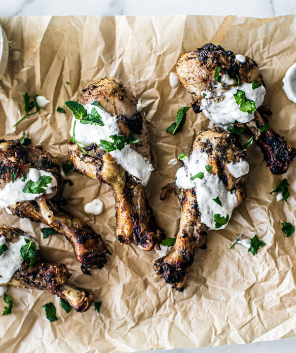 Za'atar Grilled Drumsticks laid out on parchment with lemon yogurt drizzle.