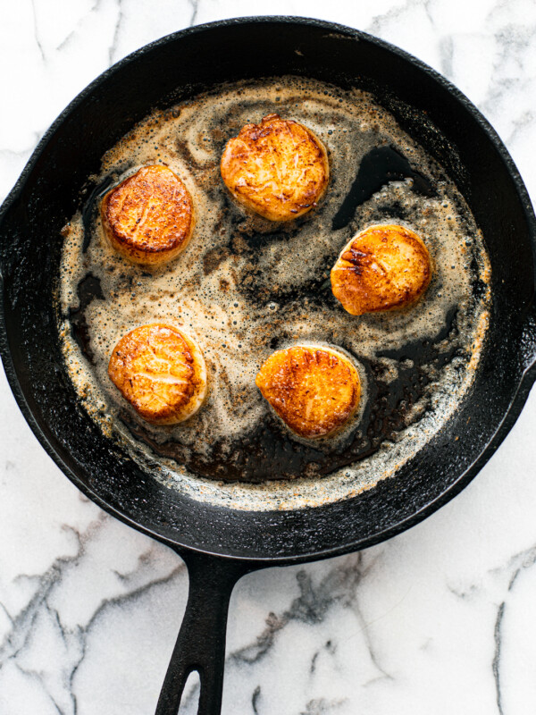 Seared Scallops in a pan with melted butter.