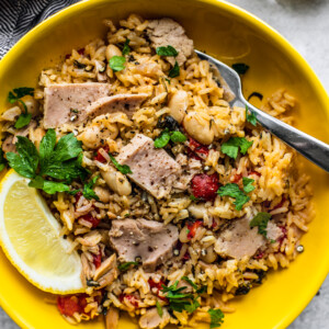 Bowl of Mediterranean Instant Pot Rice with Tuna in bright yellow bowl.