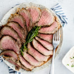 Overhead shot of platter of roast beef sliced up, medium rare.