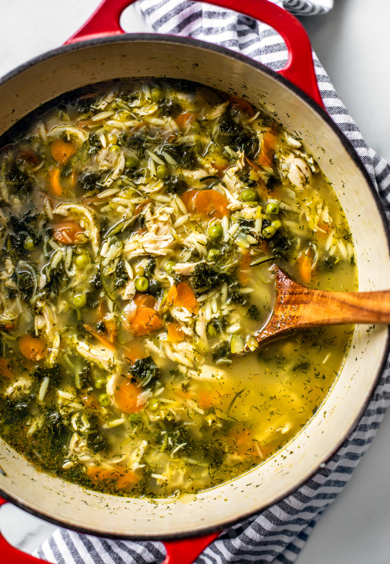 Overhead shot of red cast iron pot filled with lemon chicken orzo soup.