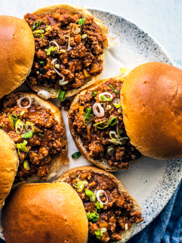 Sloppy Joes on a serving platter with a blue hand towel on the side.