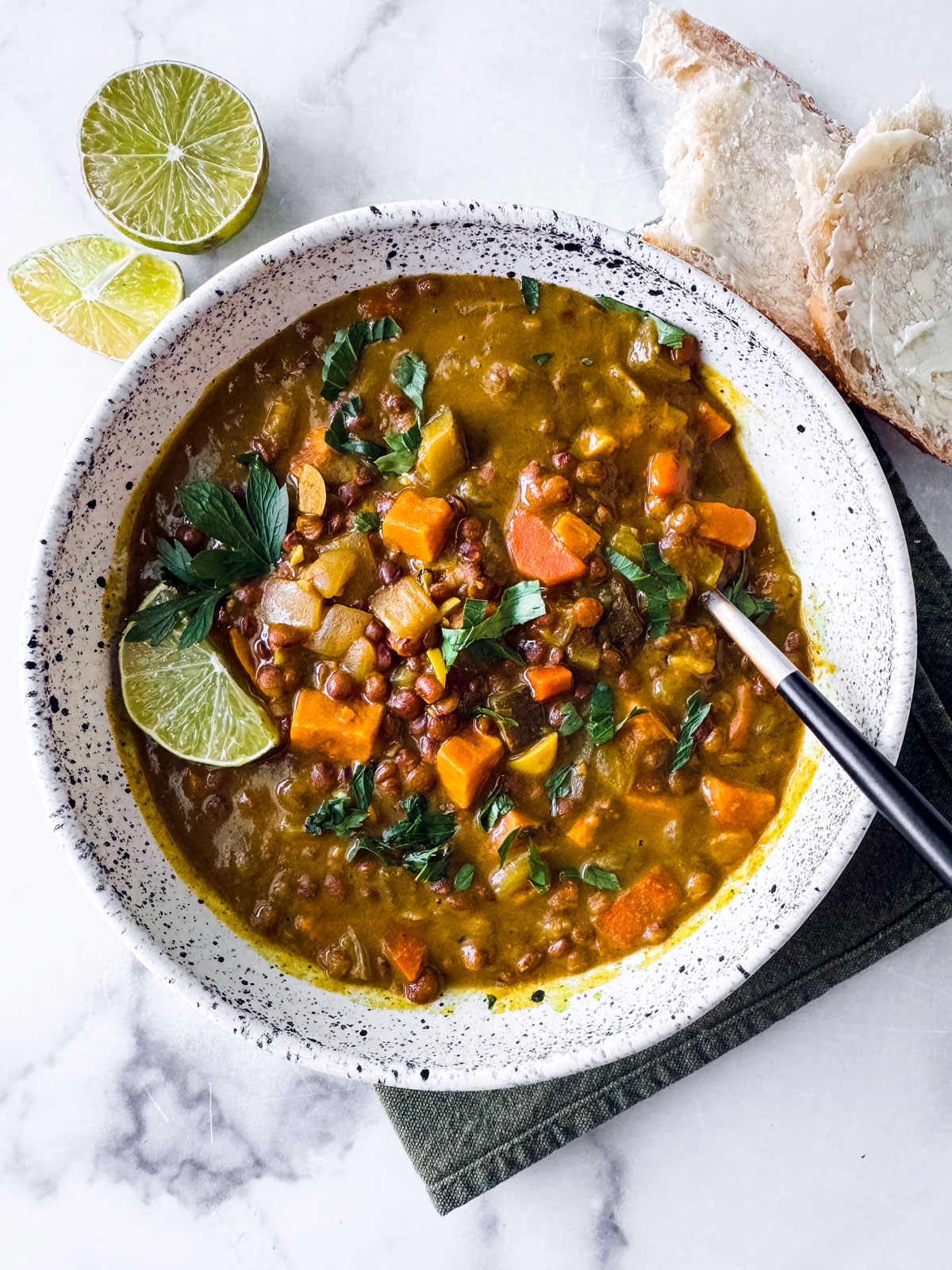 Big bowl of instant pot lentil soup with a lime wedge.