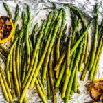 Grilled asparagus on tin foil with charred lemons.