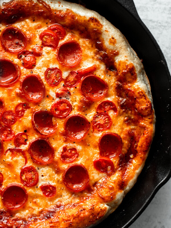 Close up of pizza in cast iron skillet.