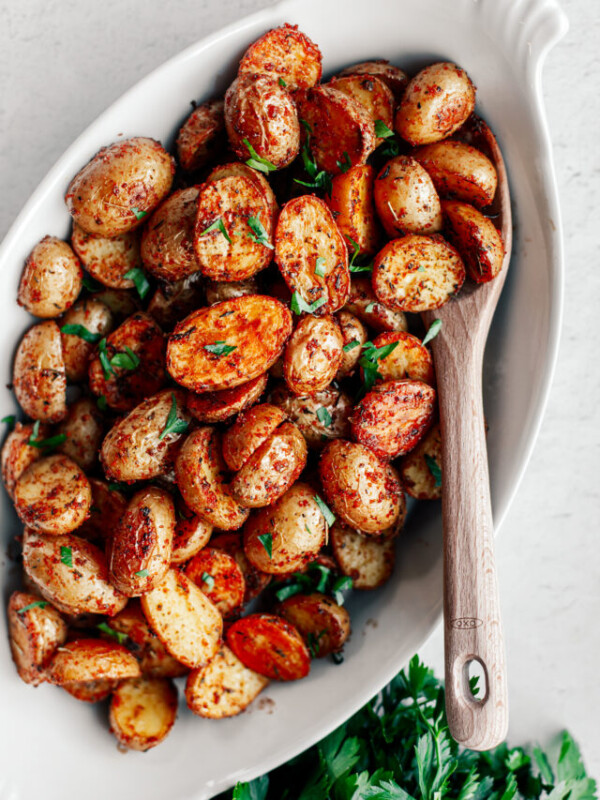 Serving platter of crispy potatoes garnished with parsley.