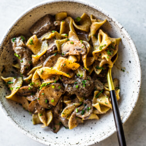 Bowl of beef stroganoff with black and gold fork.