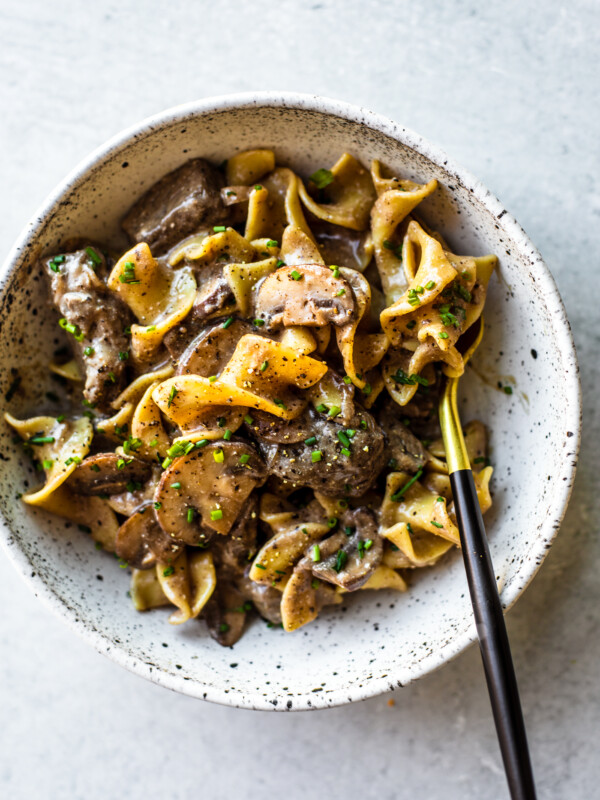 Bowl of beef stroganoff with black and gold fork.