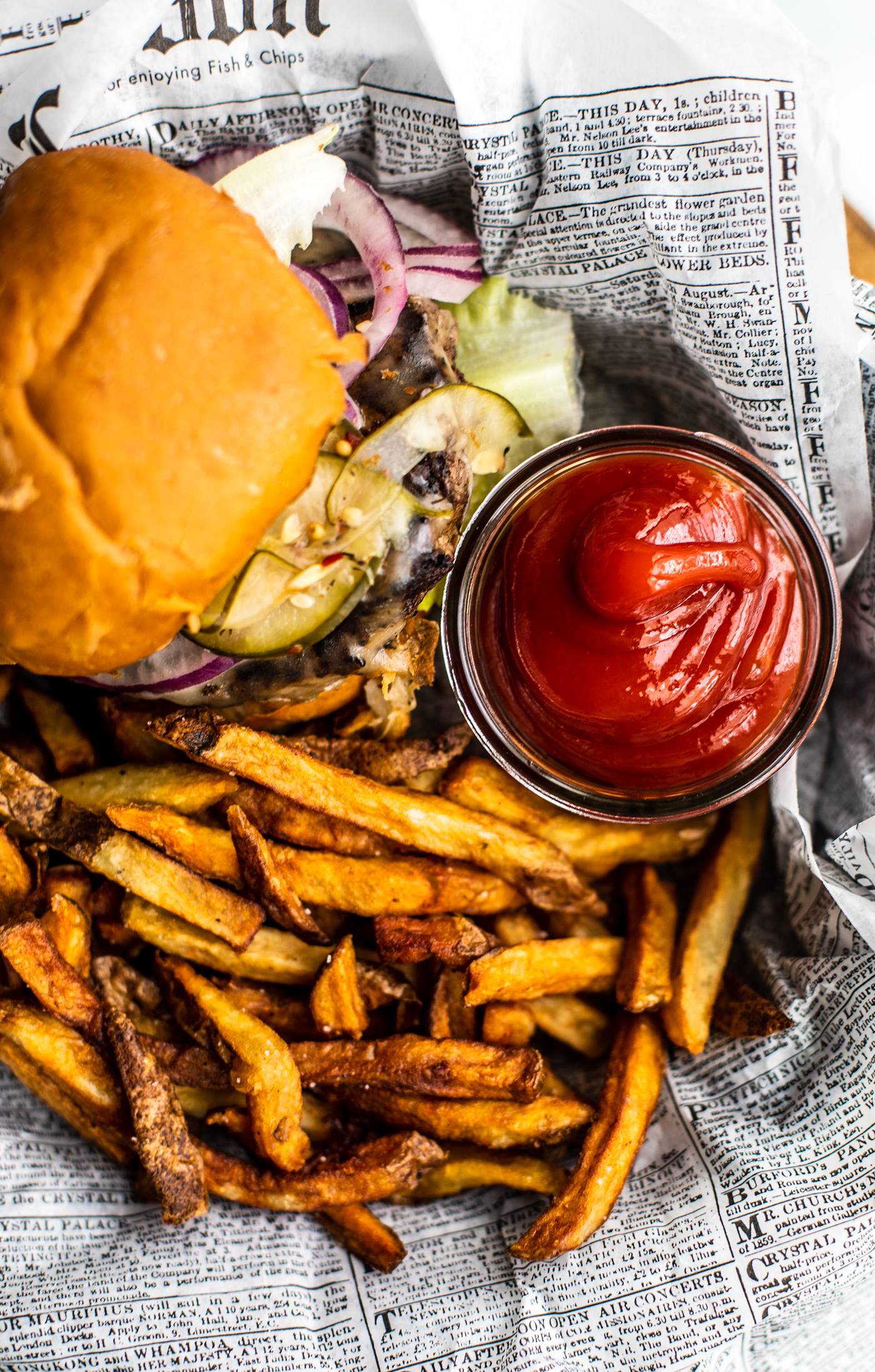 A burger and fries with a side of homemade ketchup.