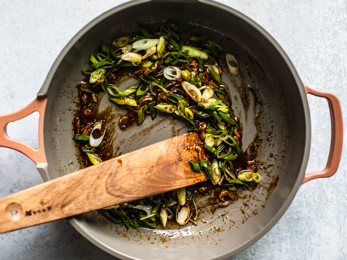 Skillet of sauce and sliced scallions.