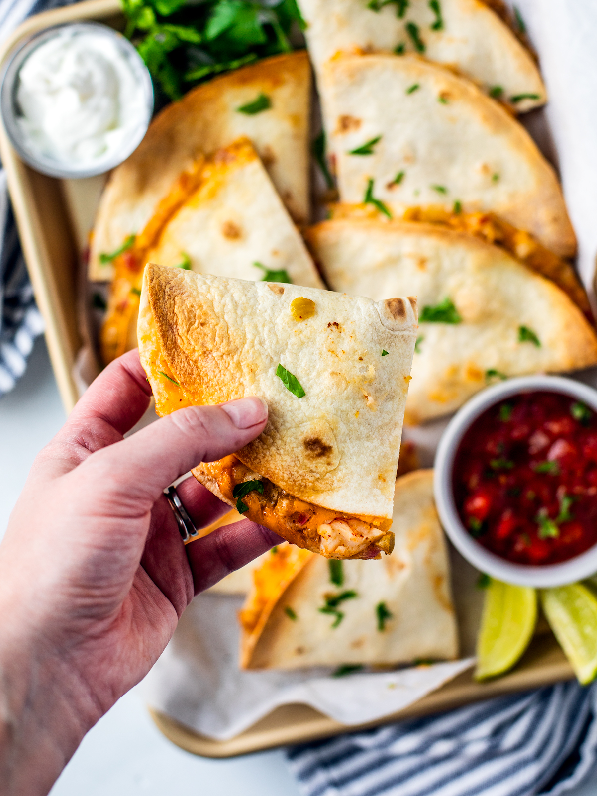 Hand grabbing a quesadilla from the serving pan.