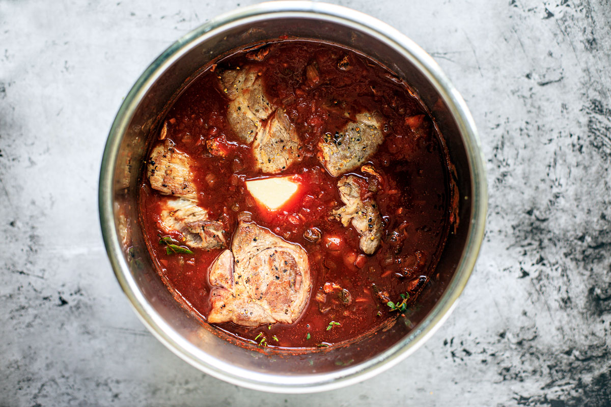 Instant Pot with seared beef chunks nestled into sauce.