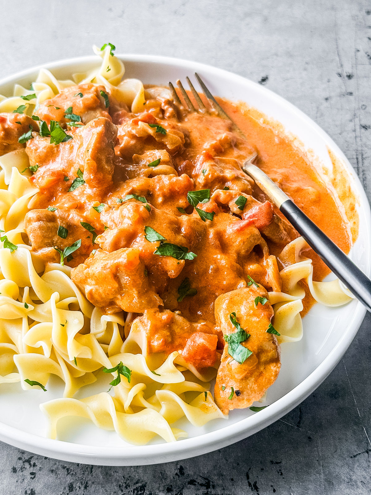 Chicken served over egg noodles.