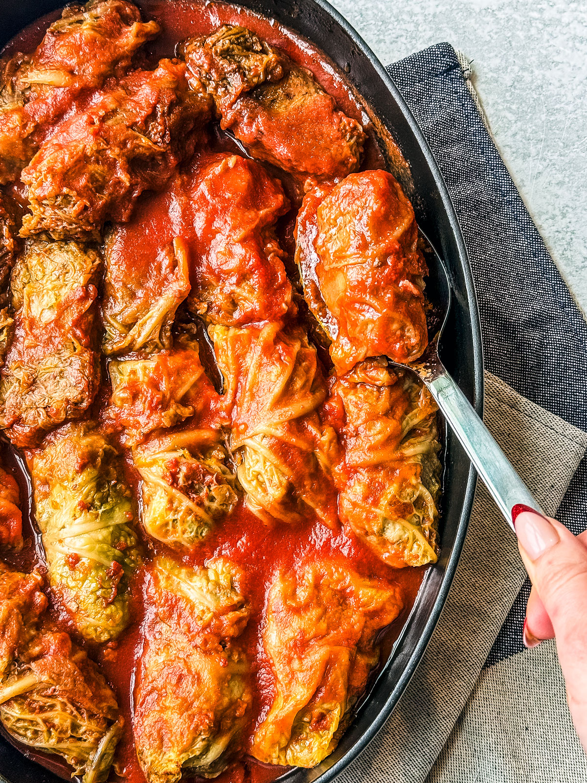 Baking tray of saucy cabbage rolls.
