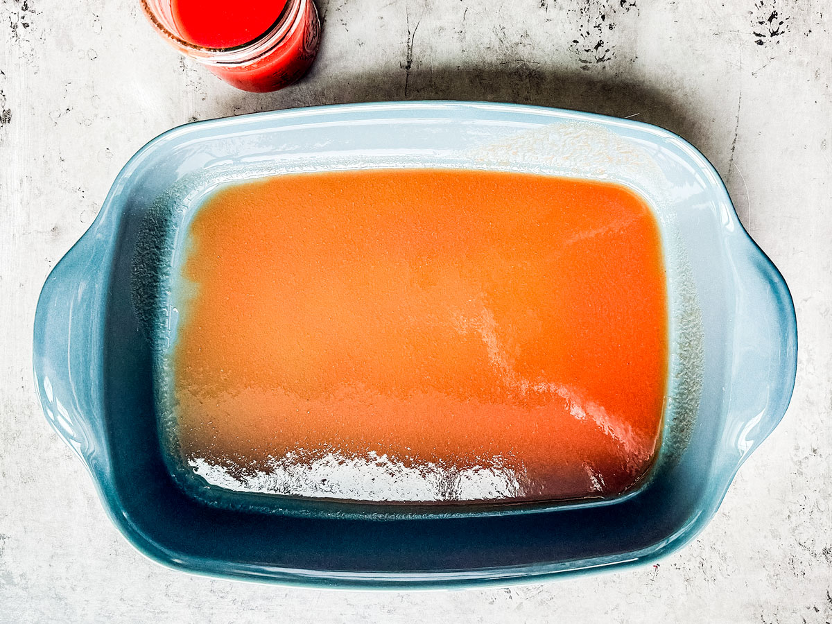 Baking dish with tomato juice covering the bottom.