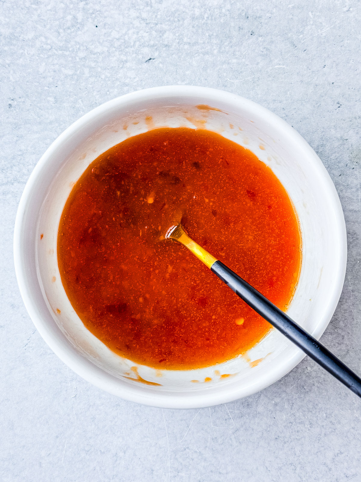 Hot honey glaze in a small bowl.