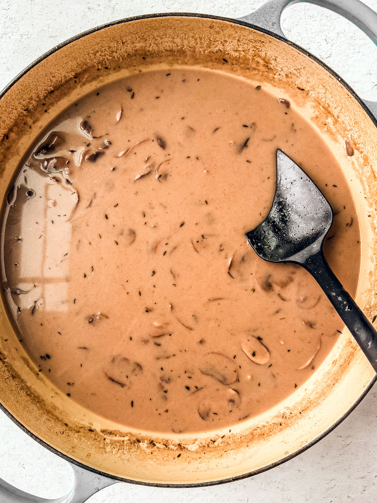 A pan full of nicely formed creamy mushroom sauce.