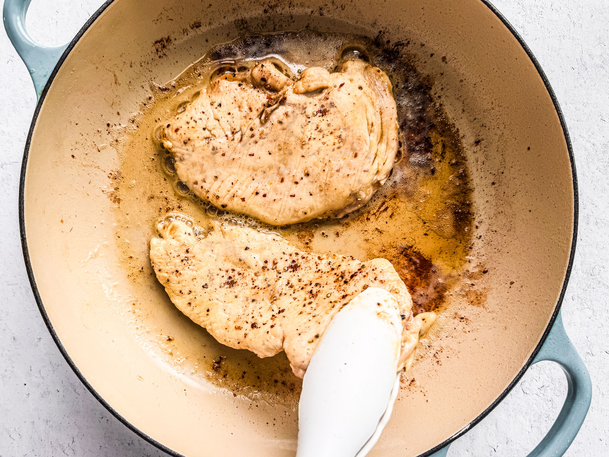 Chicken cutlets being pan-fried.