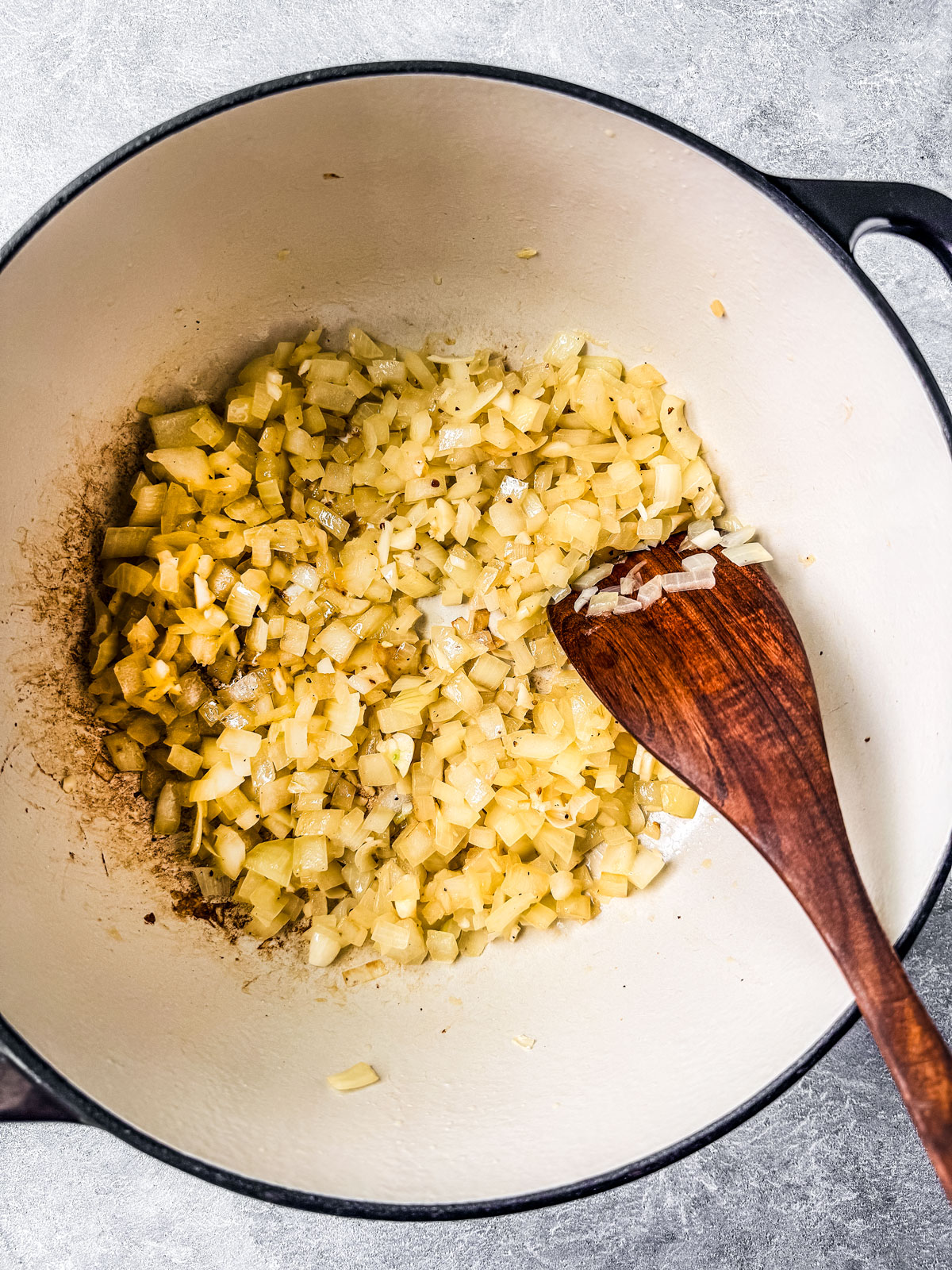 Onions being sautéd in a large pot.