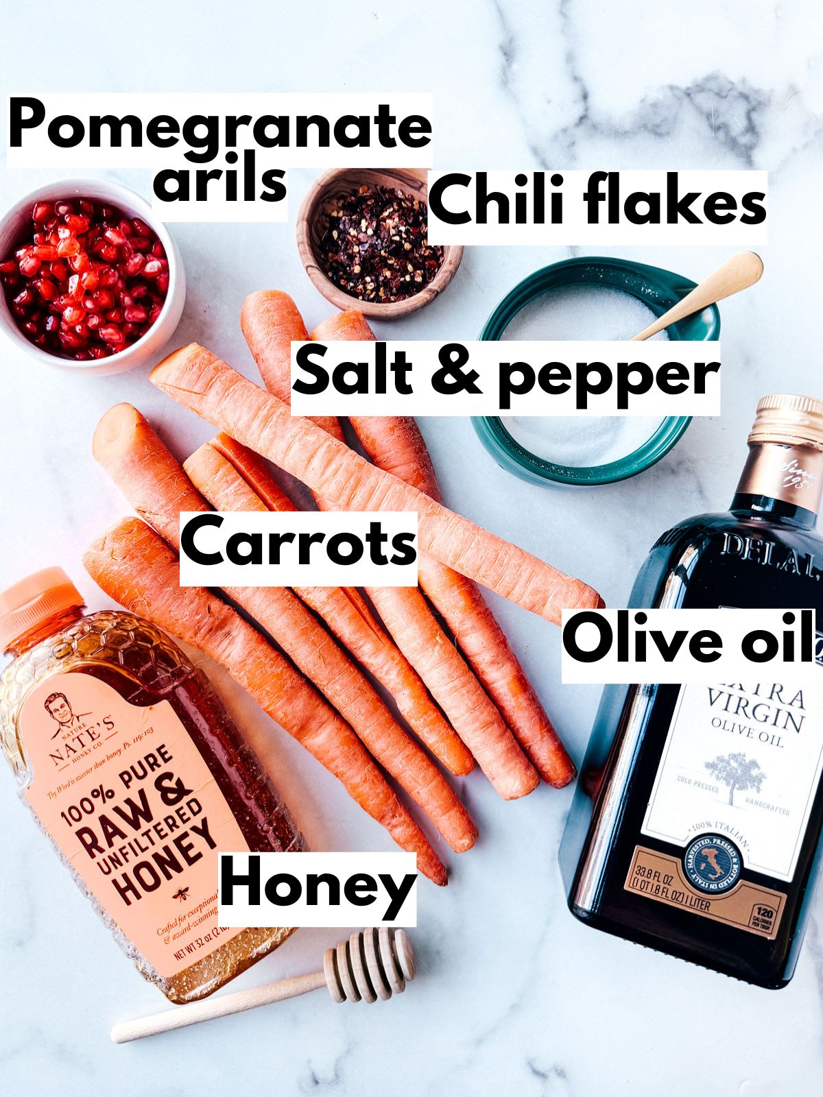 Ingredients for roasted carrots on marble background.