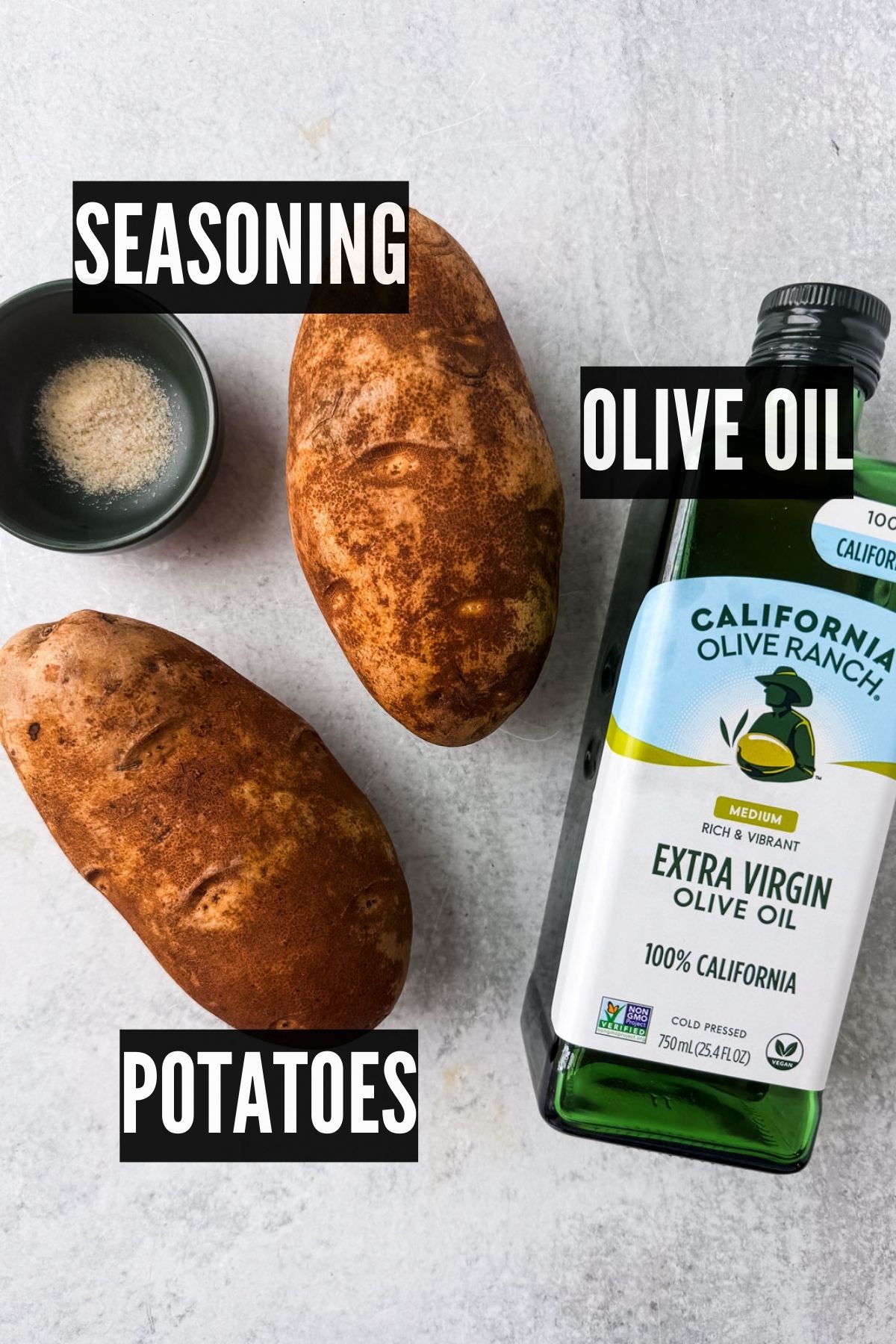 Two russet potatoes, seasoning, and a bottle of olive oil.