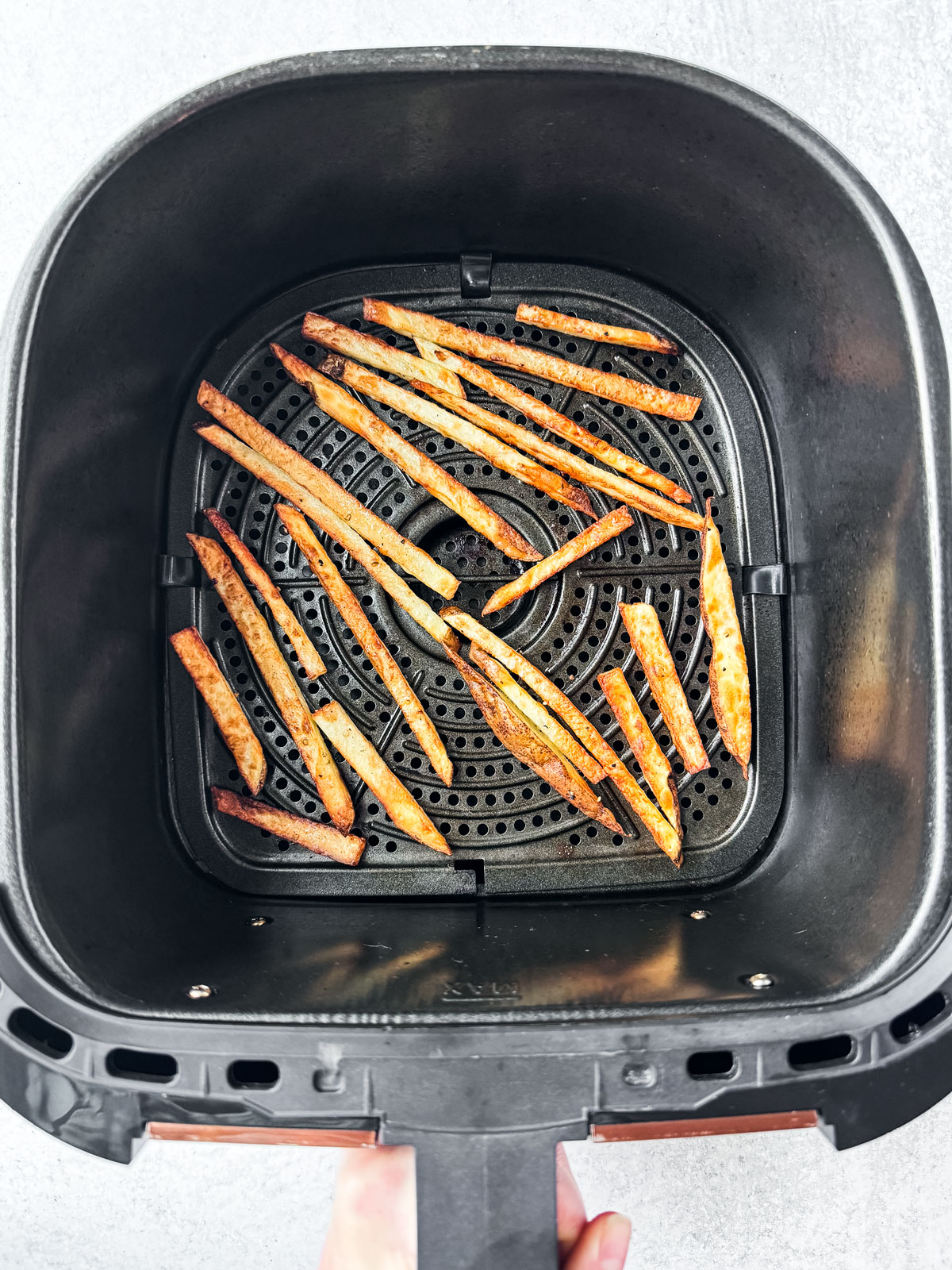 Crispy golden fries in the air fryer basket.