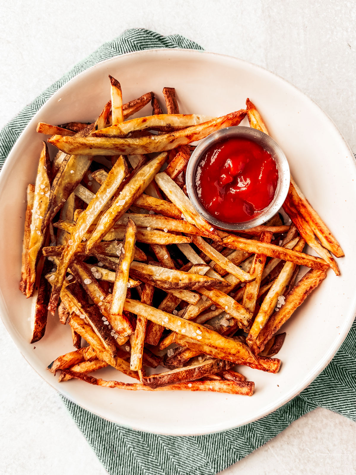 Air fryer French fries in a serving bowl with ketchup.