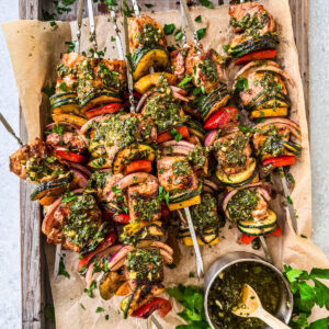 Salmon kebabs slathered in chimichurri on a serving platter.