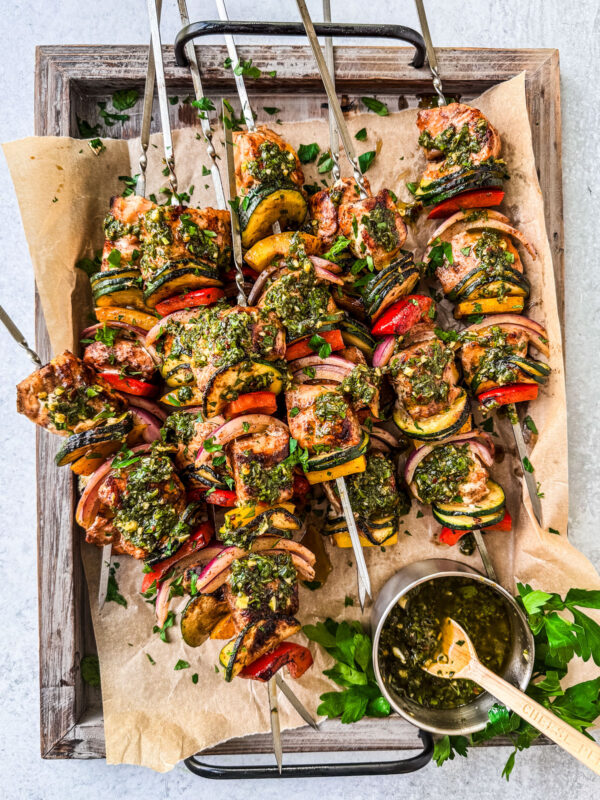 Salmon kebabs slathered in chimichurri on a serving platter.