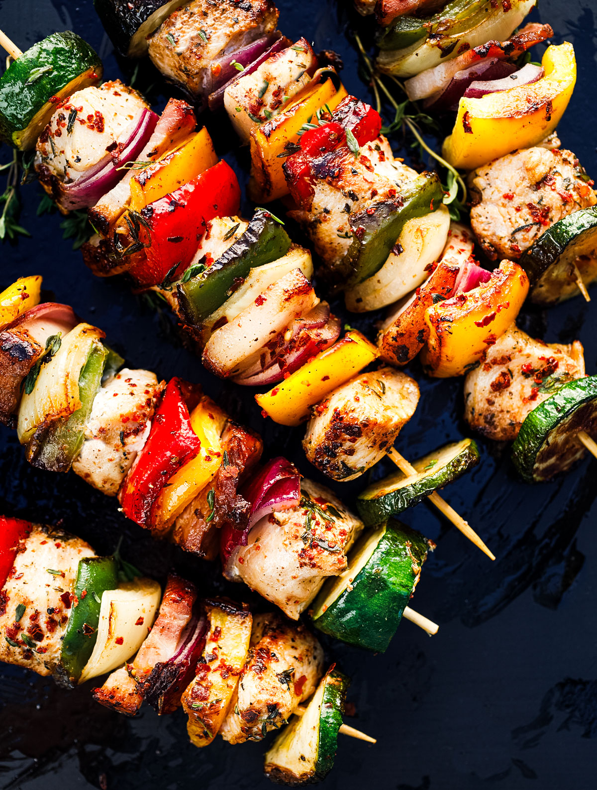 Salmon kebabs being grilled on a flat top grill.