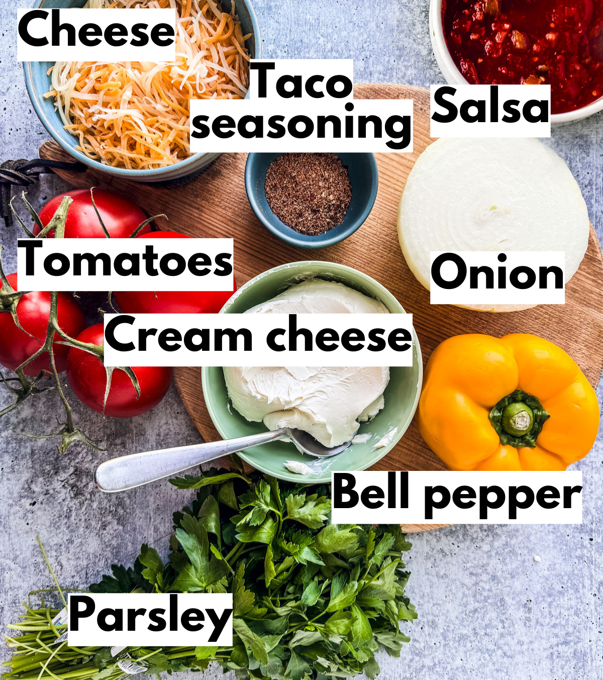 Ingredients for taco dip on a blue background.