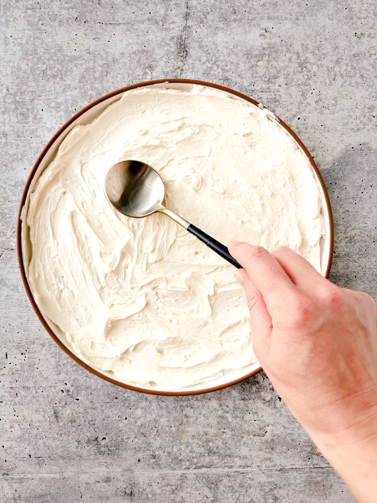 Cream cheese being layered onto a serving plate.